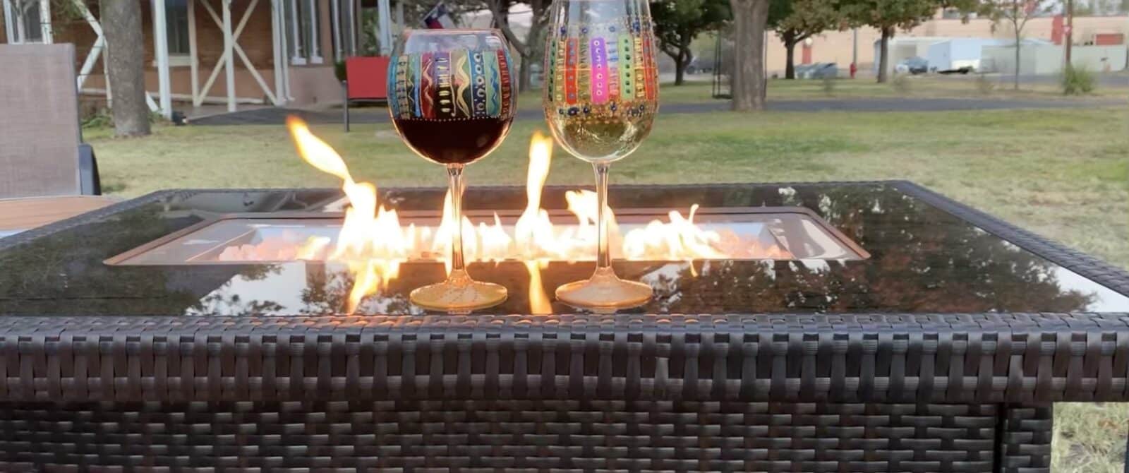 a fire pit with flames and two wine glasses on it