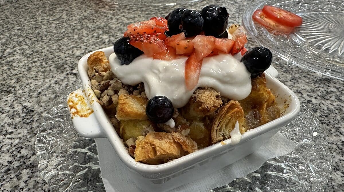 strawberry bread pudding with yogurt and berries on top